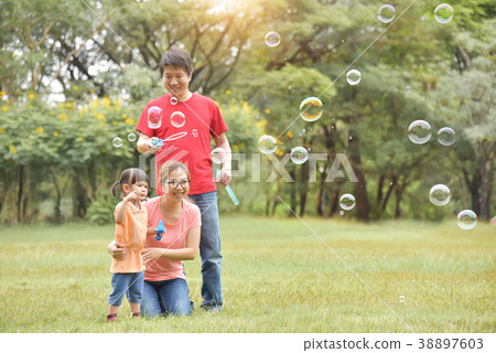 Asian family are blowing soap bubbles together. Asian family are blowing soap bubbles together. 38897603