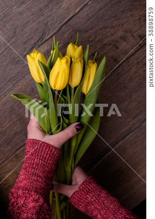Female hands with yellow tulips 38898759