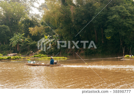 Asian fisherman on wooden longtail boat in river 38898777