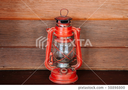Old vinatge red kerosene oil lamp on wooden wall Old vinatge red kerosene oil lamp on wooden wall 38898800