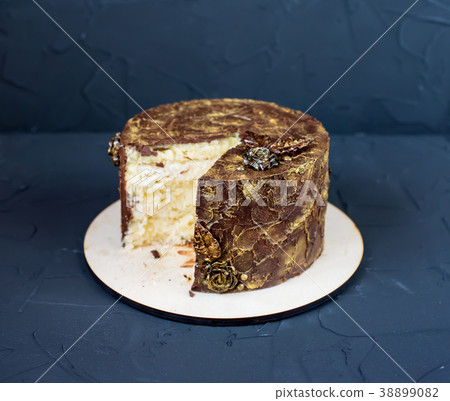 Round cake with a cut piece in center, chocolate 38899082