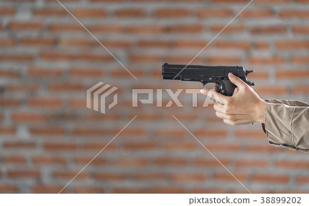 Woman's hand holding a pointing gun. 38899202