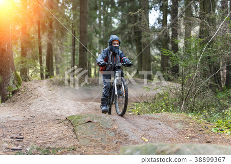 Boy riding a bicycle in the autumn in the forest 38899367