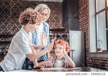 Delighted positive boys giving each other high Delighted positive boys giving each other high 38900110