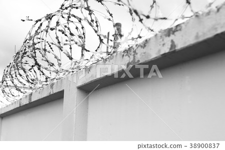 Concrete wall with barbed wire on fence Concrete wall with barbed wire on fence 38900837