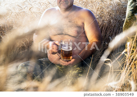 large glass of light beer is held by a fat man large glass of light beer is held by a fat man 38903549