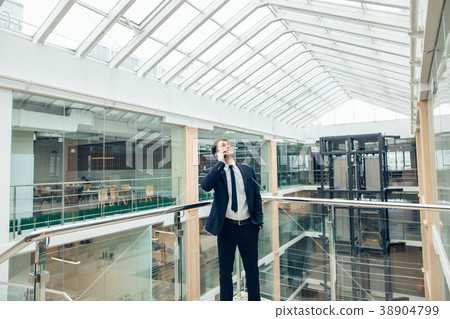 Business man walking while talking on mobile phone 38904799