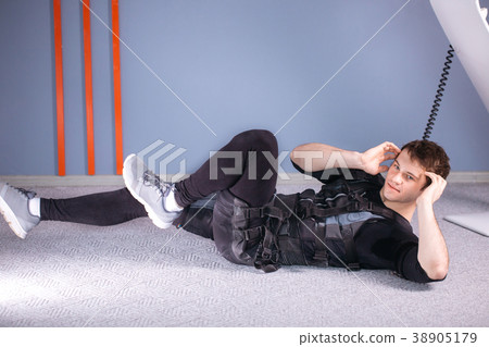 athlete wearing ems suit doing abs exercise or sit athlete wearing ems suit doing abs exercise or sit 38905179