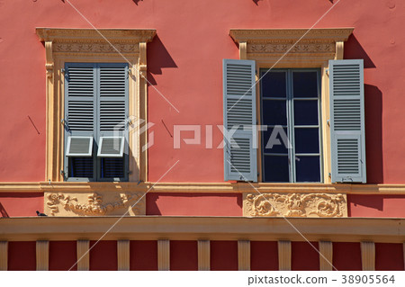 Ornate windows with grey shutters in old red house Ornate windows with grey shutters in old red house 38905564