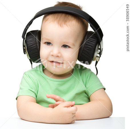 Cute little boy enjoying music using headphones Cute little boy enjoying music using headphones 38906549