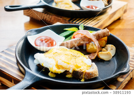Egg benedict with sausage bacon and tomato sauce Egg benedict with sausage bacon and tomato sauce 38911193