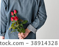 Man holding red roses hiding on back on white 38914328