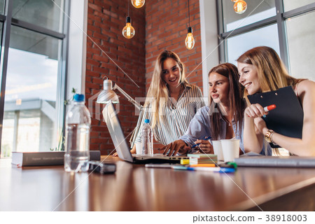 Three positive businesswomen working on laptop Three positive businesswomen working on laptop 38918003