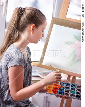 Artist painting on easel in studio. Girl paints Artist painting on easel in studio. Girl paints 38918094