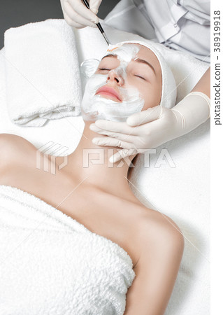 beautician applies mask to the face of woman beautician applies mask to the face of woman 38919918
