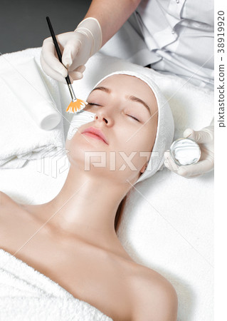 beautician applies mask to the face of woman beautician applies mask to the face of woman 38919920