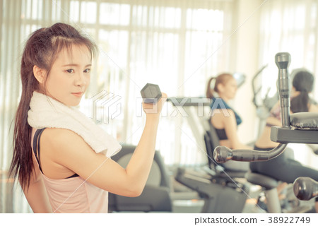 Strong woman is lifting dumbbell in fitness Strong woman is lifting dumbbell in fitness 38922749