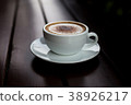 Coffee in a white cup on a wooden table. 38926217