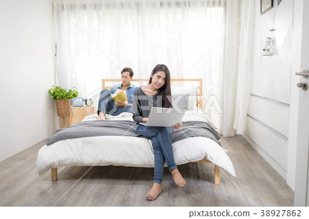Young couple relaxing at home reading a book. 38927862