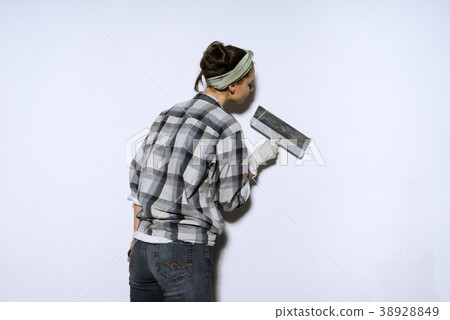 girl lining the walls with a spatula,doing repairs 38928849