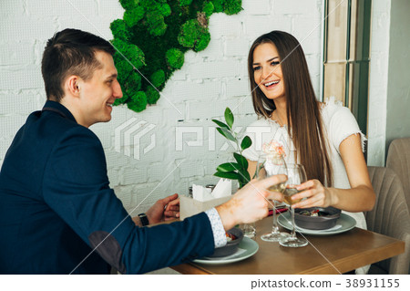 smiling couple having dinner and drinking white 38931155