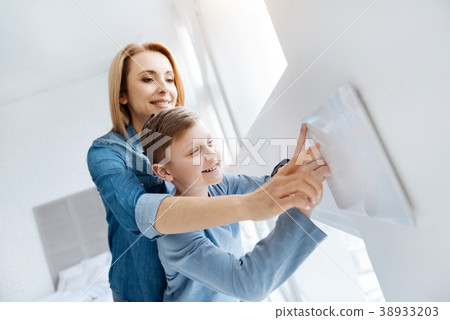 Pleasant happy woman holding her sons hand Pleasant happy woman holding her sons hand 38933203