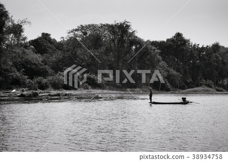 Asian fisherman on wooden boat in nature river 38934758
