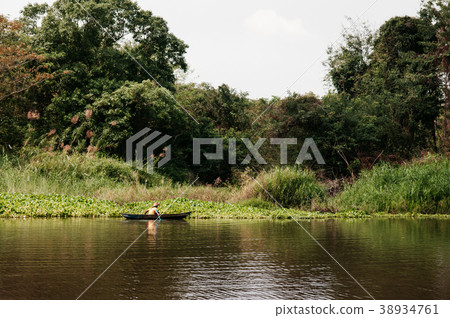 Asian fisherman on wooden boat in nature river 38934761