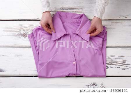Female hands and blouse, wooden background. Female hands and blouse, wooden background. 38936161