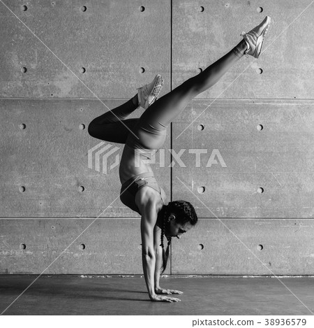 Young fit woman doing handstand exercise in studio Young fit woman doing handstand exercise in studio 38936579