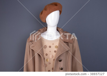 Female mannequin in top coat and beret. 38937127