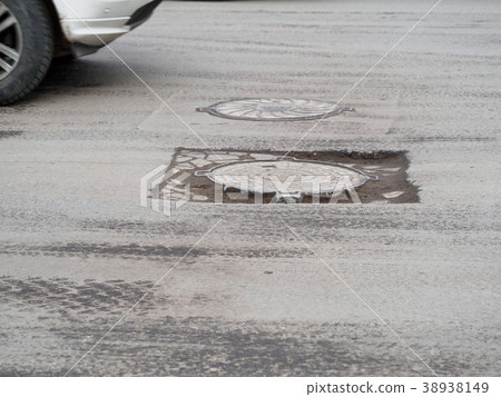 Deep pit on the road 38938149