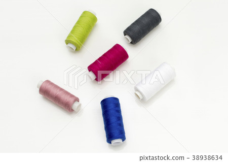 Colored thread coils on white background, sewing 38938634