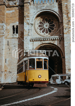 Quaint yellow tram passes directly in front of the 38940719