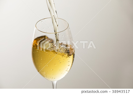 Pour white wine into the glass 38943517