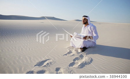 Enterprising male sheikh businessman sitting with 38944100