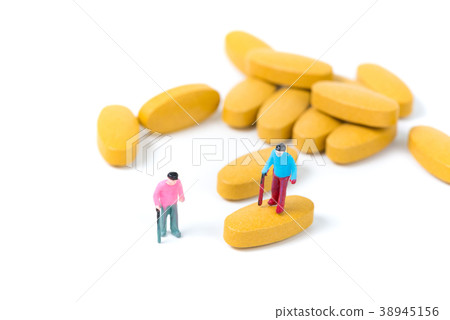 Miniature small figure old man or patient on pill Miniature small figure old man or patient on pill 38945156