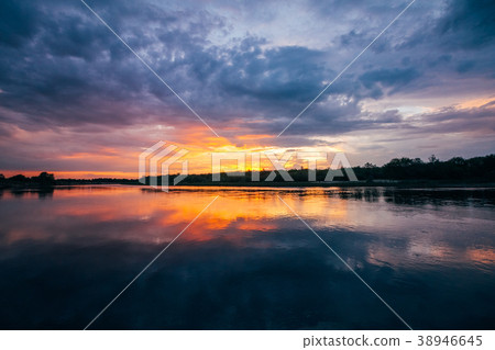 Beautiful sunset over a river with heavy clouds 38946645