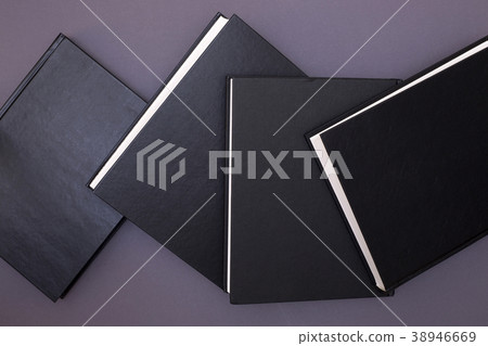 Four black books on a gray background 38946669