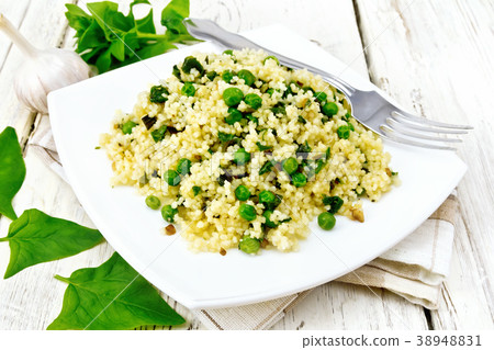 Couscous with spinach in plate on light board Couscous with spinach in plate on light board 38948831