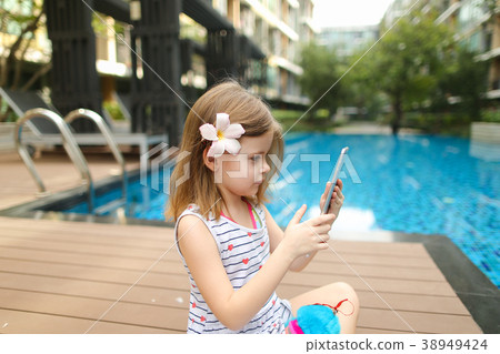 kid girl make photo on tablet sitting close to 38949424