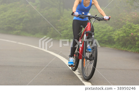 Young woman cyclist riding mountain bike on trail 38950246