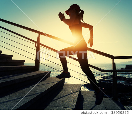 female runner running upstairs on coast trail 38950255