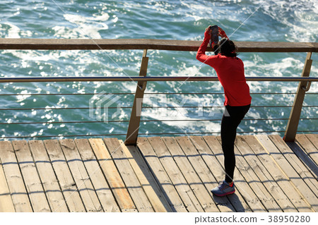 warming up stretching legs on seaside boardwalk 38950280