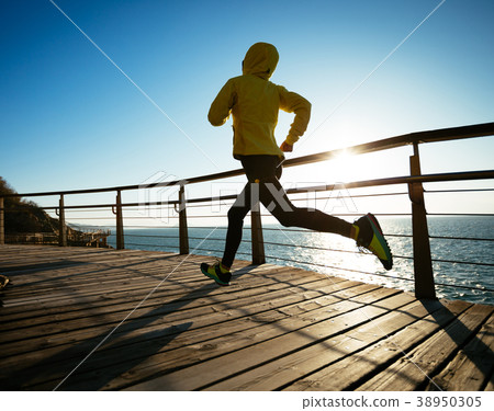 sporty runner running on seaside boardwalk sporty runner running on seaside boardwalk 38950305