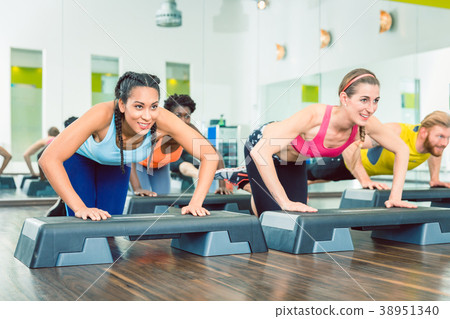 Determined women exercising push-ups on aerobic 38951340