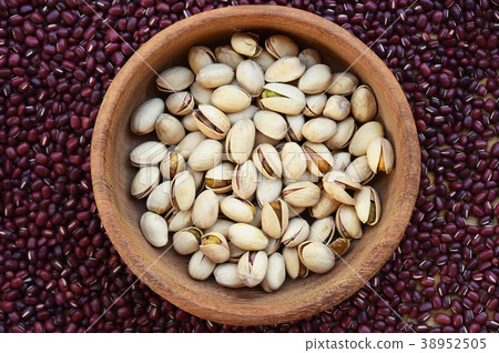 pistachios in wooden bowl on red bean background 38952505