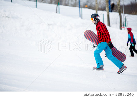Image of sporty man with snowboard walking on 38953240