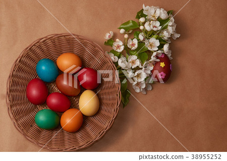 Colorful Easter eggs in basken and white flowers Colorful Easter eggs in basken and white flowers 38955252