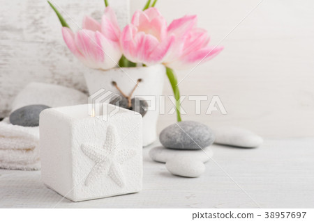 Pink tulips, pebbles and lit candle Pink tulips, pebbles and lit candle 38957697